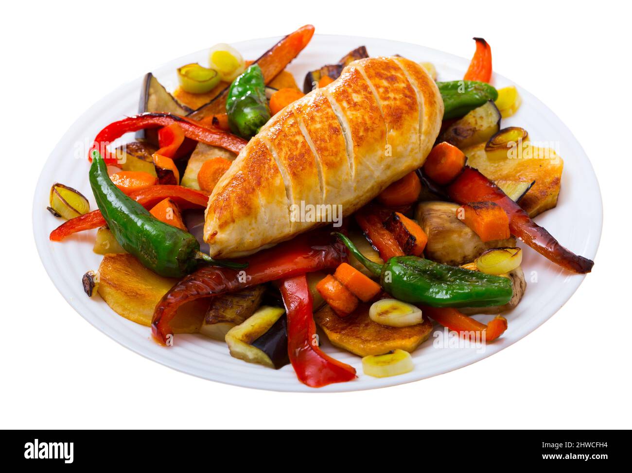 Top view of tasty baked different vegetables with chicken fillet at plate. Isolated over white background Stock Photo