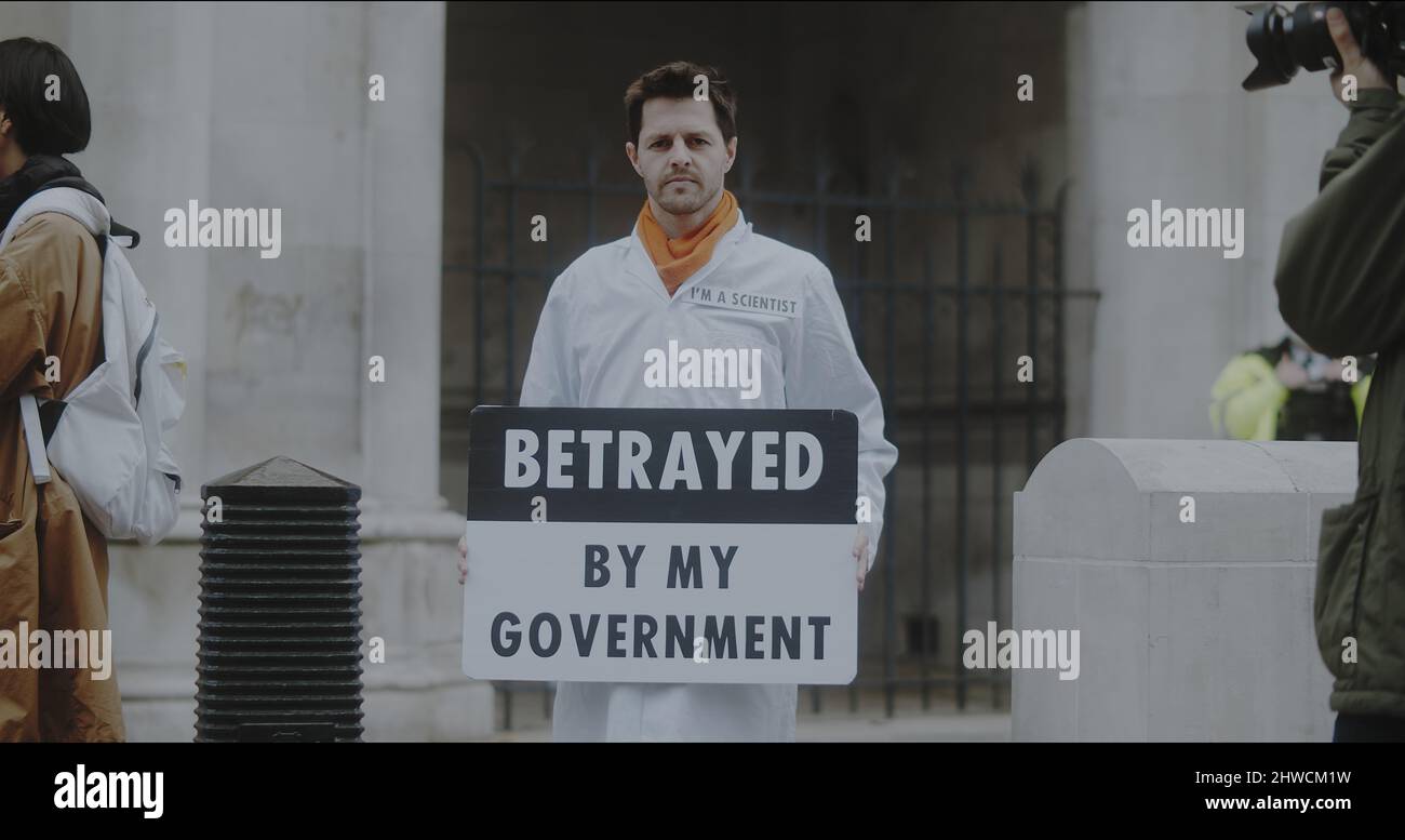 London, UK - 11 20 2021:  A man scientist holding a sign ‘Betrayed By My Government’, in support for in prisoned Insulate Britain campaigners. Stock Photo