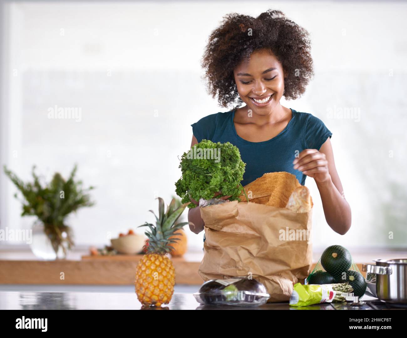 I hope the chef gets a kiss afterwards. Cropped shot of a young woman with some groceries. Stock Photo