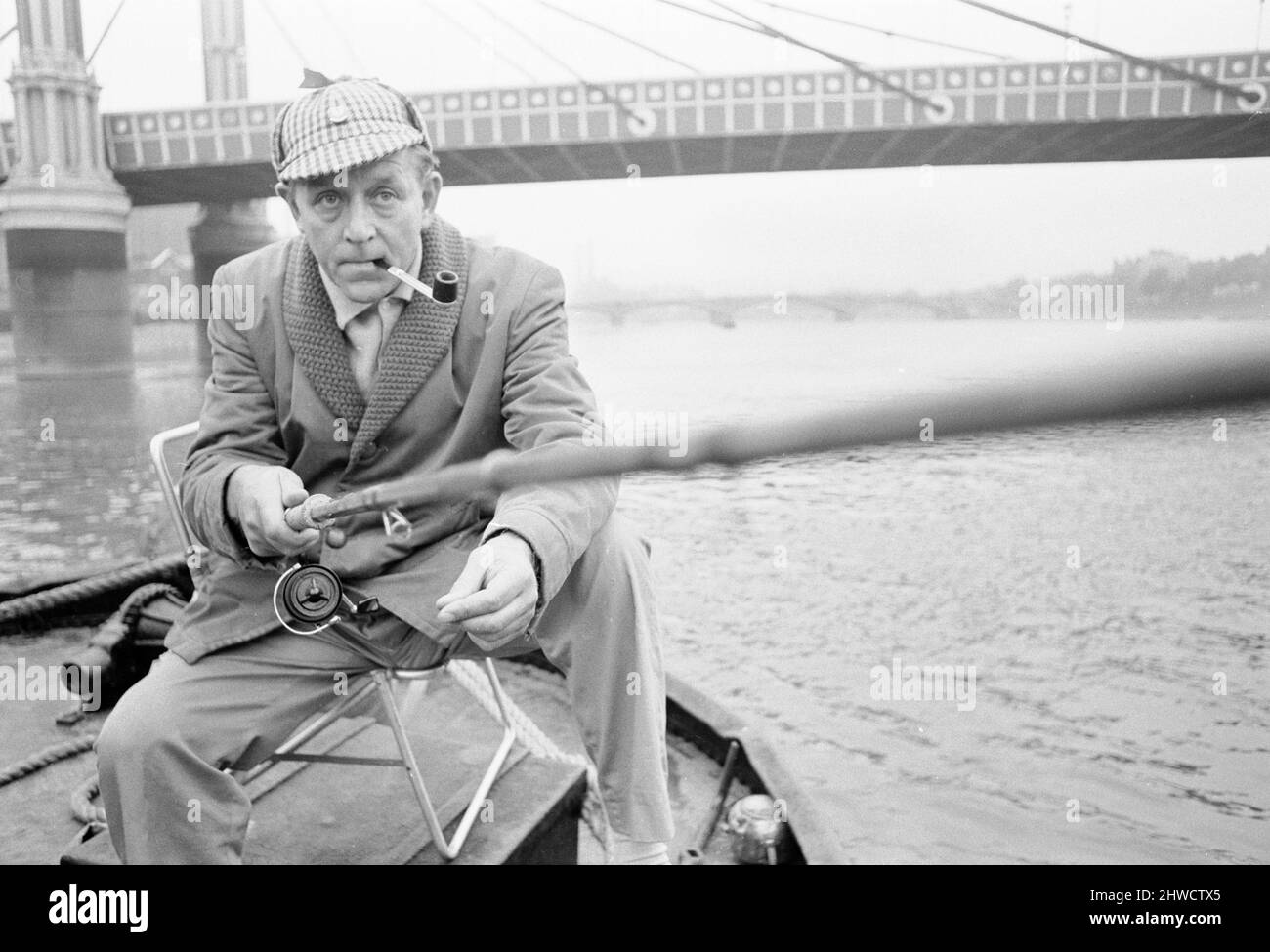 An angler from the Soho Firestation seen here fishing off a barge moored close to Battersea Bridge.  14th September 1969 Stock Photo