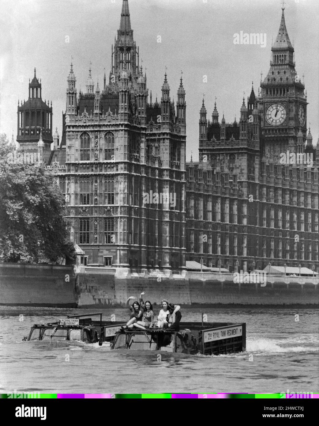 Army Vehicles. Amphibious.  Two Army trucks transport three waving women through the water of the river Thames.   June 1970 P035494 Stock Photo