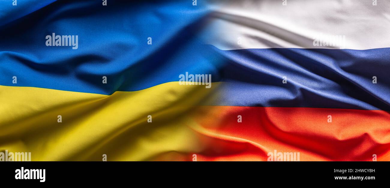 Ukrainian and Russian flags next to each other blending into one. Stock Photo