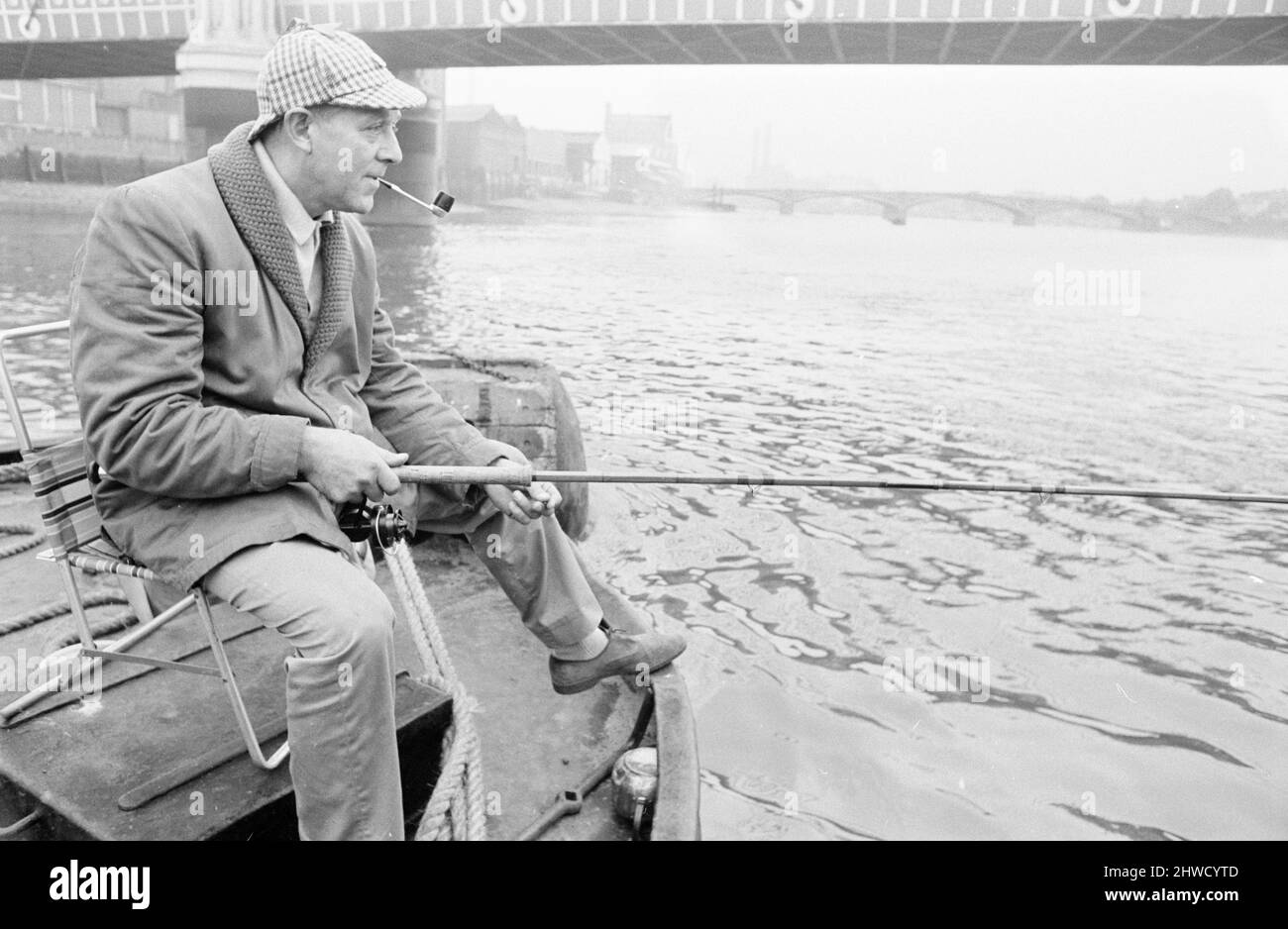 An angler from the Soho Firestation seen here fishing off a barge moored close to Battersea Bridge.  14th September 1969 Stock Photo