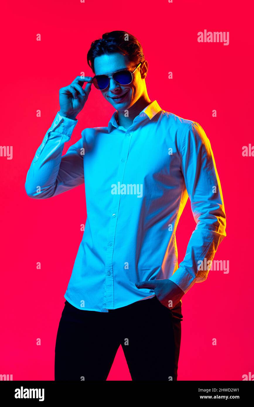 Portrait of young handsome man in stylish sunglasses and white shirt ...