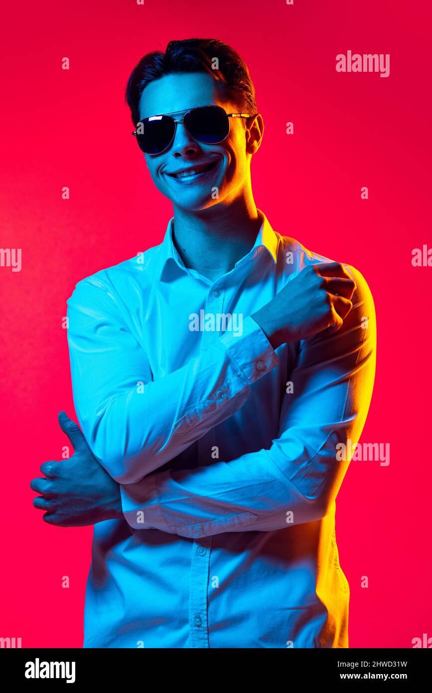 Portrait of young handsome man in stylish sunglasses and white shirt ...