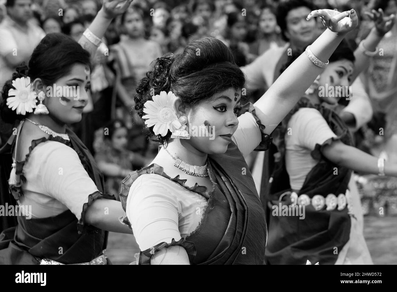 Kolkata, India - 21st March, 2019 : Girl dancers dressed in sari, traditional Indian dress with Palash flowers, Butea monosperma, make up, dancing at Stock Photo