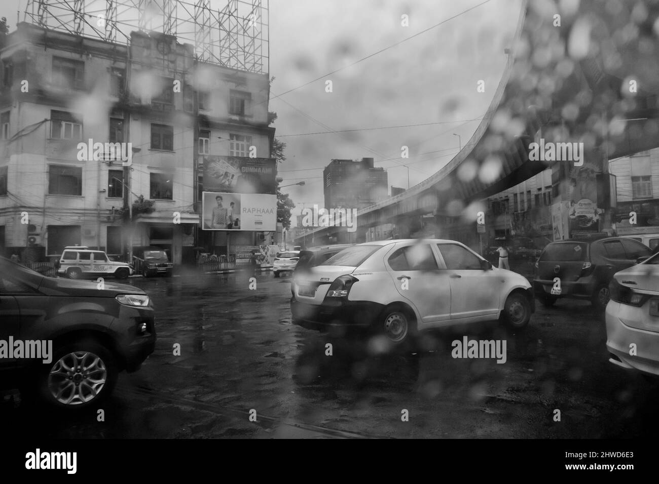Kolkata, West Bengal, India - 25th September 2019 : Image shot through raindrops falling on wet glass, abstract blurs of traffic - monsoon stock image Stock Photo