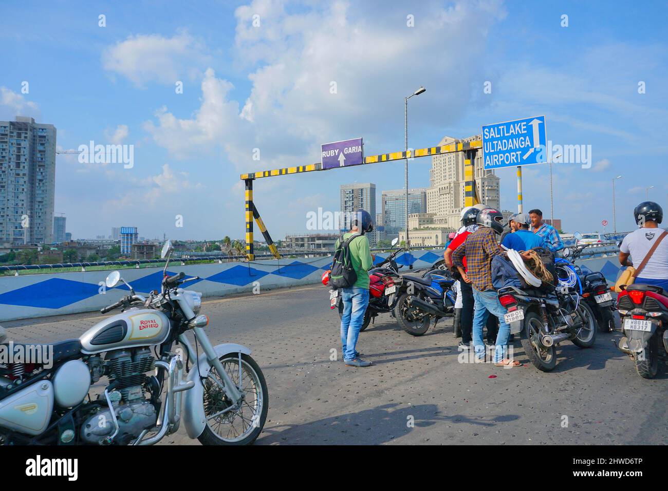 Kolkata, West Bengal, India - 20th July 2019 : Bikers assembled on Maa flyover to resolve a traffic issue, modern buildings, blue sky and white cloud Stock Photo
