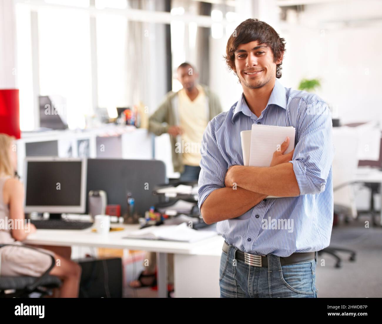 Enthusiastic. A handsome young businessman holding his notepad and ...
