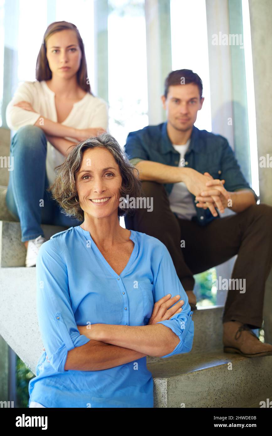 Theyre still my spring chickens. Shot of a mother standing in front of her adult children on the stairs. Stock Photo