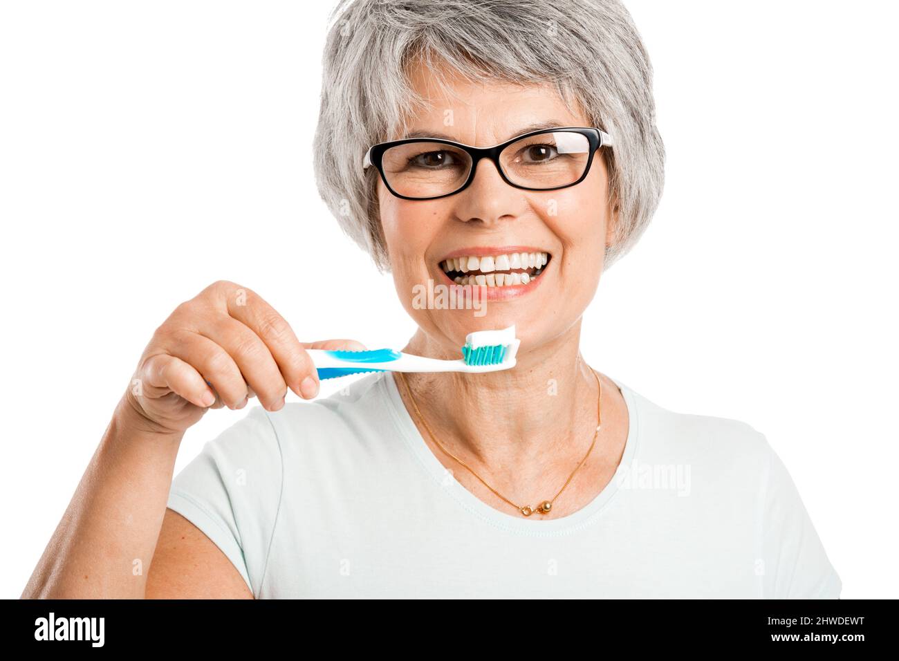 Portrait of a happy old woman brushing her teeth Stock Photo