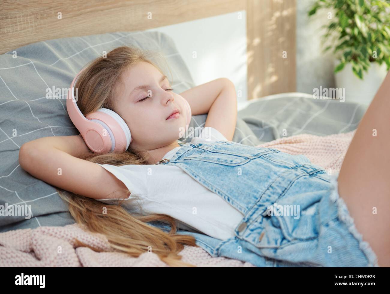 Adorable little girl in headphones enjoy with a music Stock Photo - Alamy