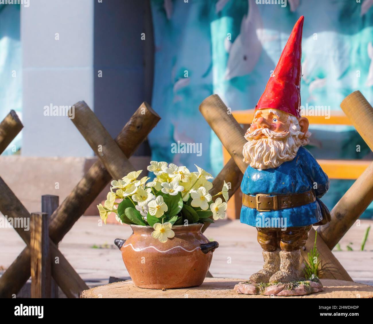 Decoration of a country house. A toy ceramic gnome and a pot with a ...