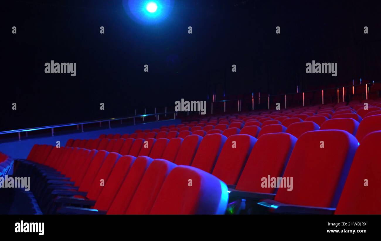 Empty rows of seats in cinema hall. Empty movie theater with red seats