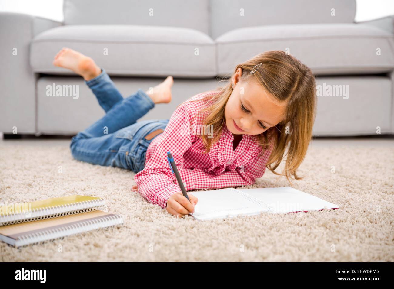 Cute little girl at home studying Stock Photo - Alamy