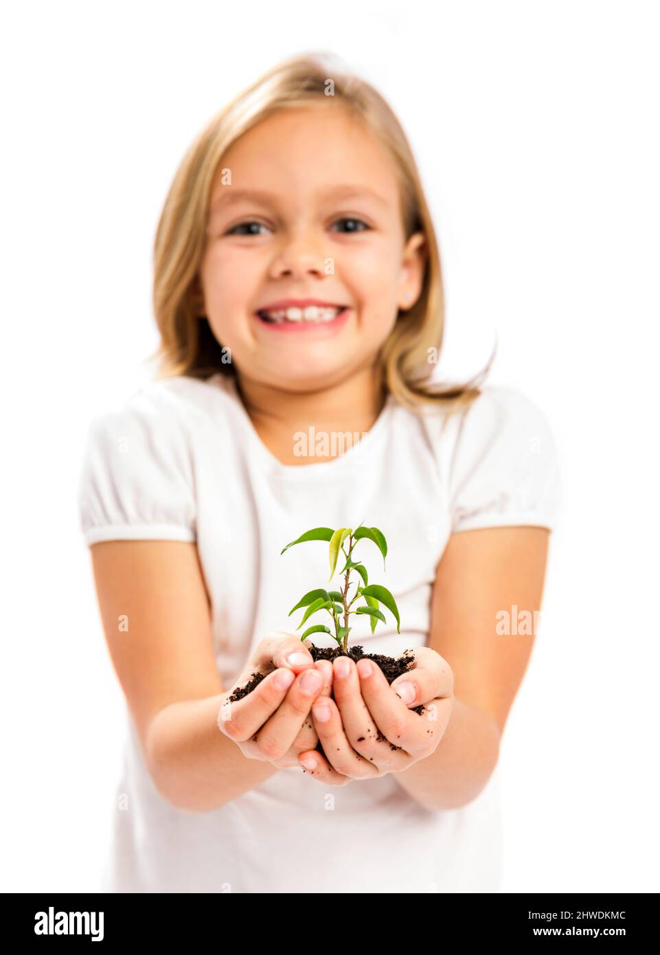 Happy little girl showing a plant on her little hands Stock Photo