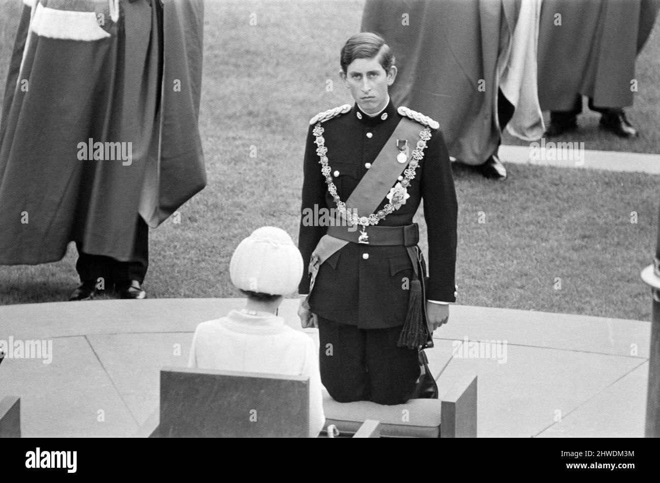 The Investiture of Prince Charles at Caernarfon Castle. Caernarfon, Wales. Prince Charles kneels