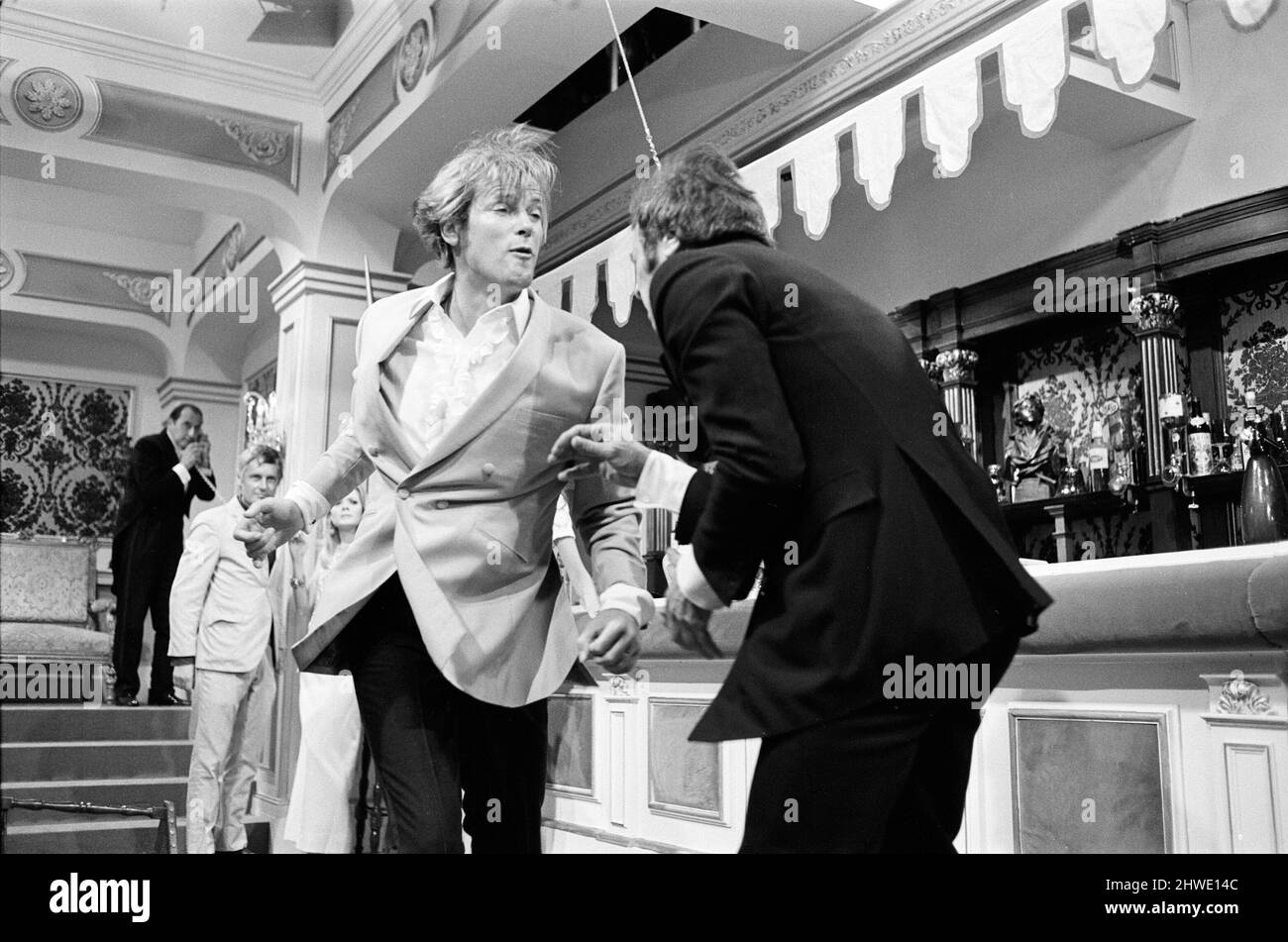 Roger Moore and Tony Curtis fight with each other on the set of The Persuaders! at Pinewood Film Studios, Iver, Bucks. Roger plays an English Lord, who meets Tony (playing a brash Brooklyn self made millionaire) and in this opening sequence they have a spectacular running fight across a restaurant. 11th August 1970. Stock Photo