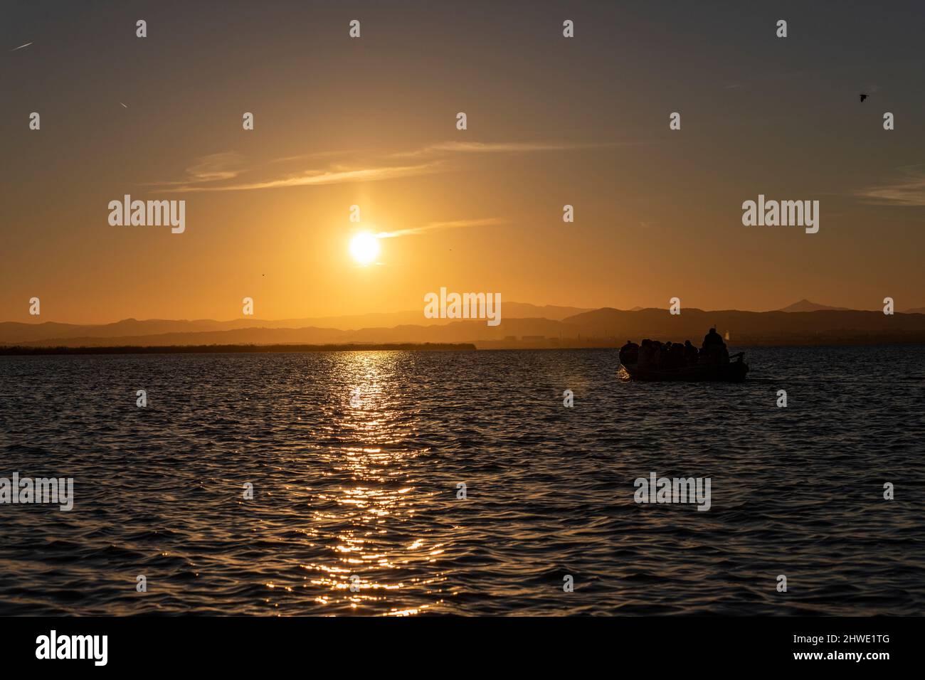 Tourist boat trip during sunset on the Albufera lagoon. La Albufera,  Valencian Community, Spain. Stock Photo