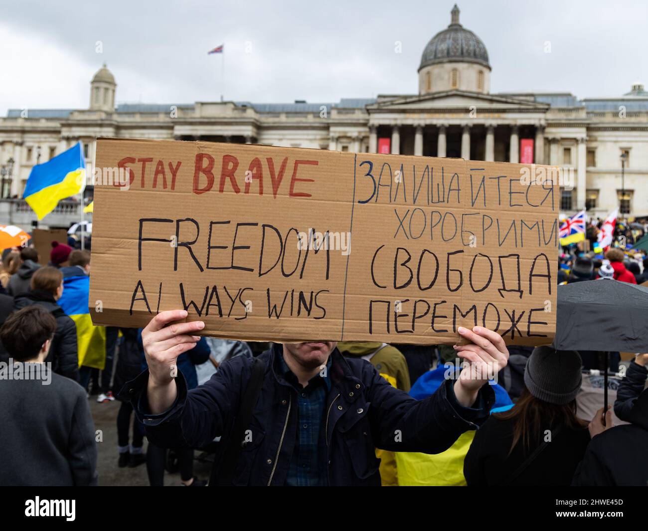 London, UK. 05 March 2022. At a peace demonstration against the Russian invasion of Ukraine a demonstrator holds a sign in front of his face that reads 'STAY BRAVE FREEDOM ALWAYS WINS' © Matt Goodrum/Alamy Live News Stock Photo