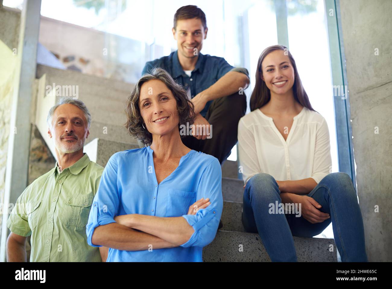 Welcome to our happy home. Shot of a mother and father standing in front of their adult children on the stairs. Stock Photo