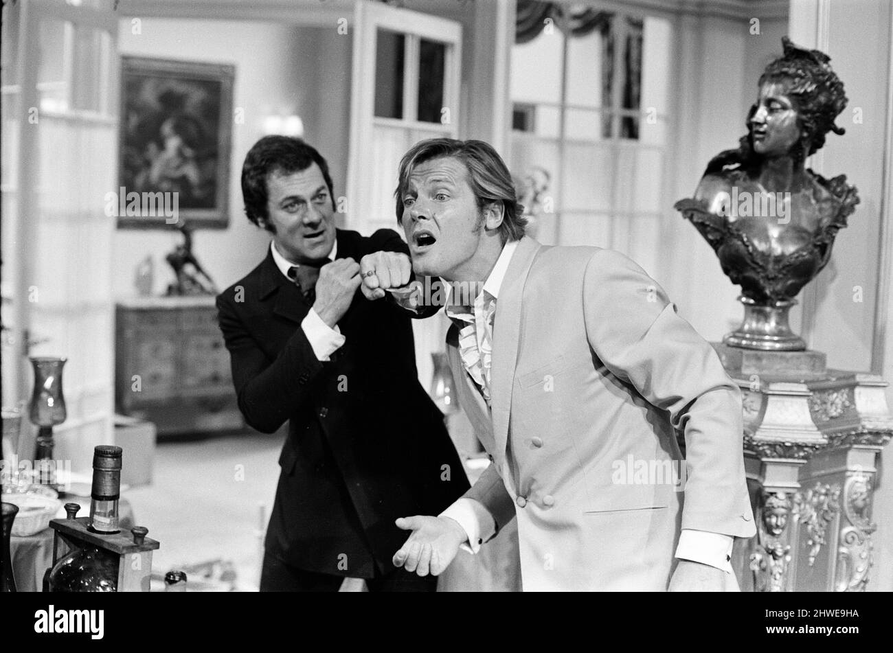 Roger Moore and Tony Curtis fight with each other on the set of The Persuaders! at Pinewood Film Studios, Iver, Bucks. Roger plays an English Lord, who meets Tony (playing a brash Brooklyn self made millionaire) and in this opening sequence they have a spectacular running fight across a restaurant. 11th August 1970. Stock Photo