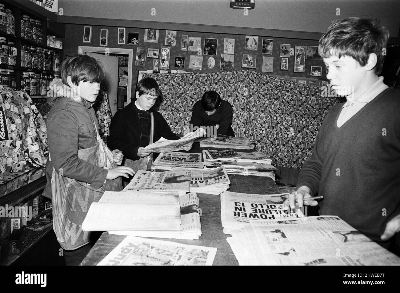 Newspaper round boys inside a newsagents, sorting the papers ready for delivery. 18th April 1970. Stock Photo