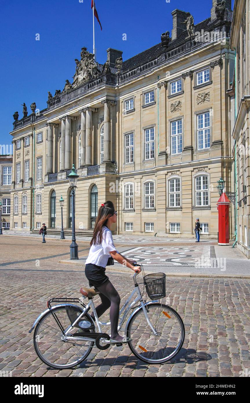 Woman on bicycle, Christian VIII's Palace, Amalienborg Royal Palace, Royal Palace Square, Copenhagen (Kobenhavn), Kingdom of Denmark Stock Photo