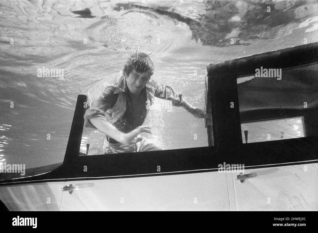 27 year old actor Michael Crawford, who doesn't use stunt men in dangerous parts, filming underwater with a Rolls Royce at MGM Studios, Elstree for the new Twentieth Century Fox production, 'Hello - Goodbye'. Scenes shot underwater were the final sequences of the original top surface sequence performed in Cannes, where Crawford drove the Rolls into a swimming pool. He was required to hold his breath for the cameras for 3 minutes before the 'rescue' was made. 17th October 1969. Stock Photo