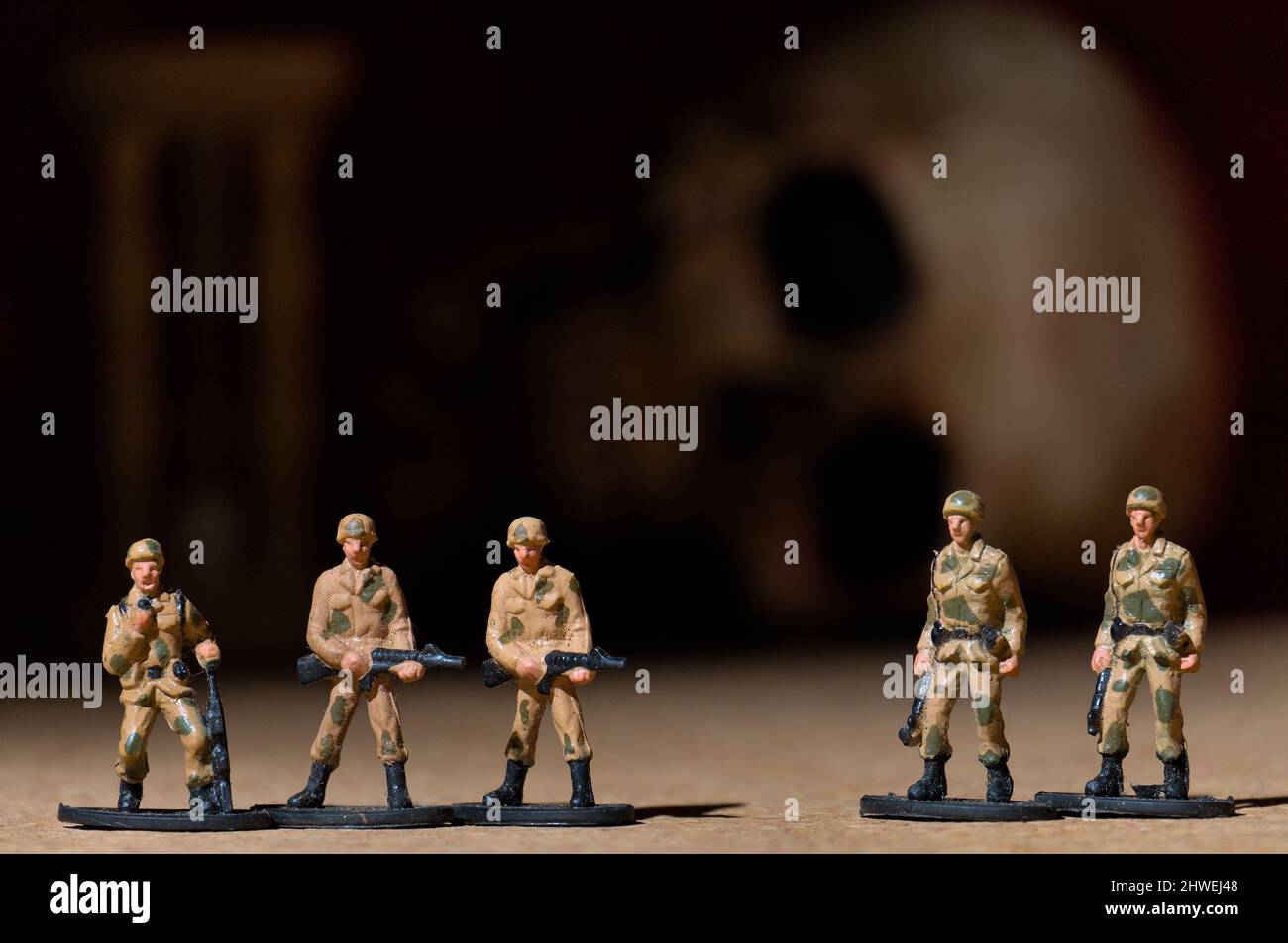Toy soldiers with human skull and hourglass on the background. War Concept Photography Stock Photo
