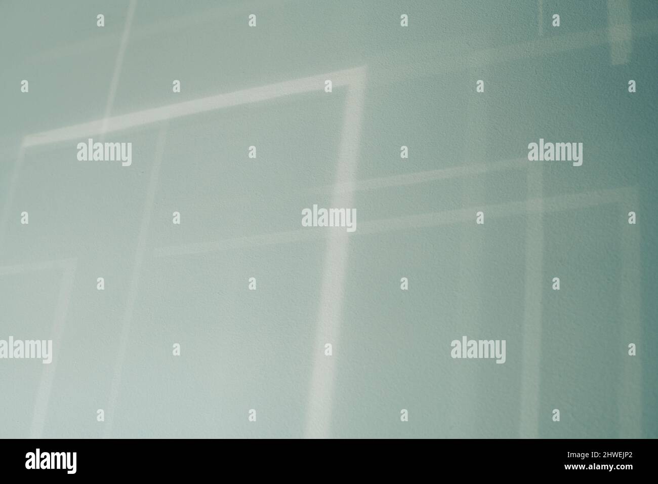 Abstract shadows from blinds on a blue wall . Stock Photo