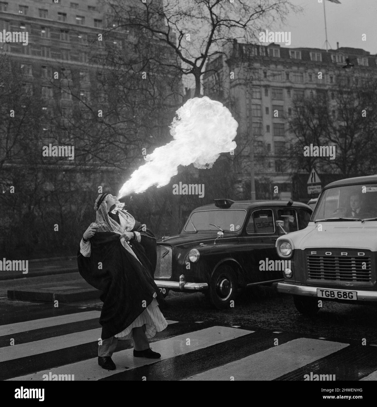 Sammy Kamel, a young Egyptian fire eater stops traffic in London. 23rd April 1970 Stock Photo