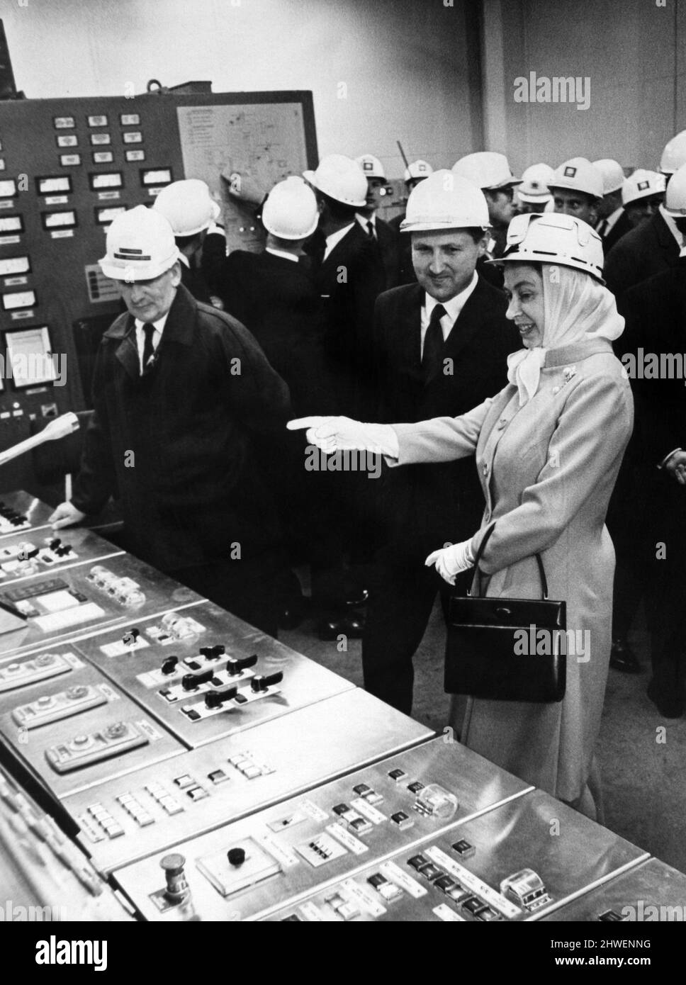 Queen Elizabeth II wearing protective clothing, watches the control