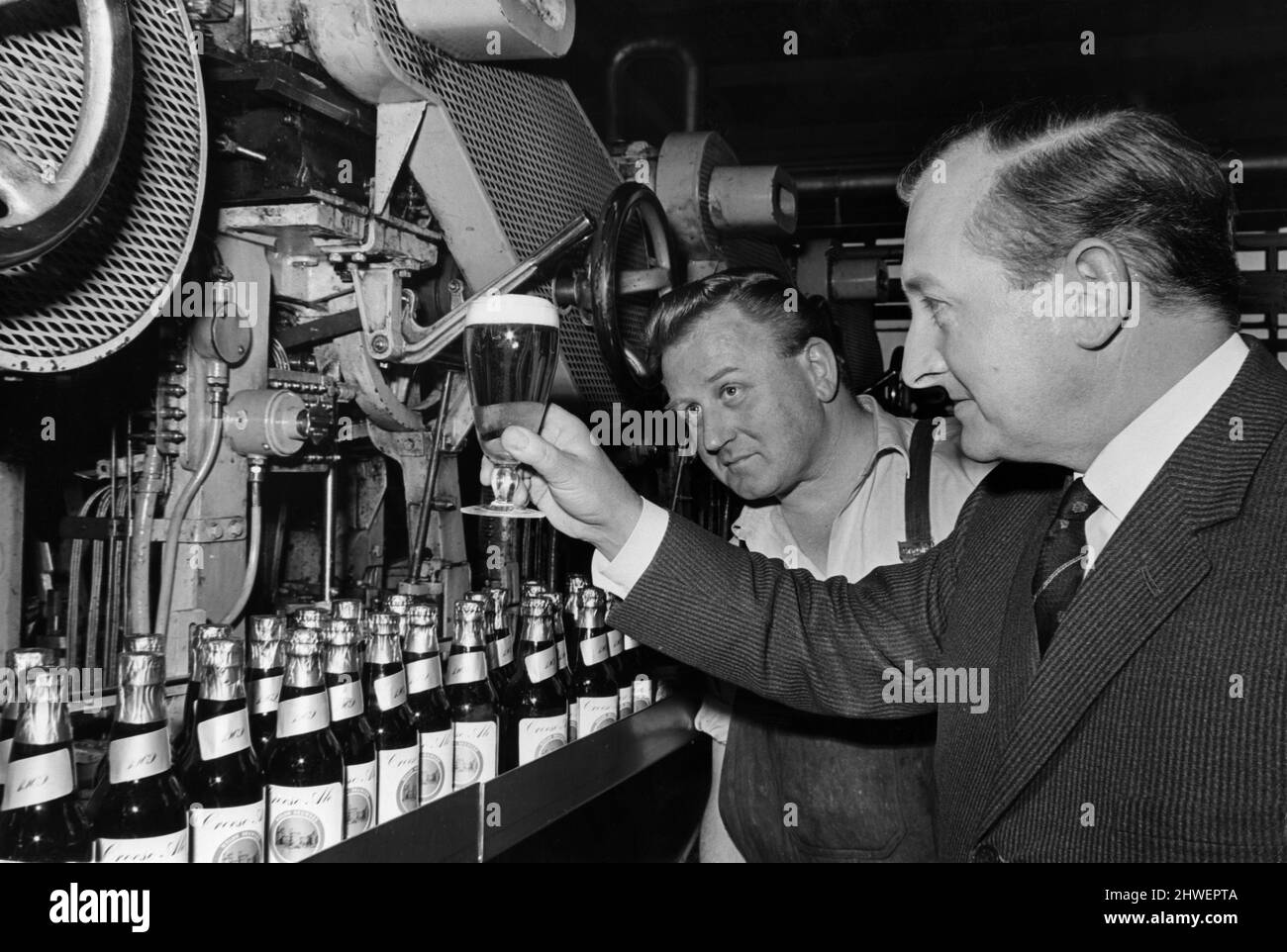 Mr Ken E J Morison (right) Brewing Director, Welsh Brewers Ltd., of Crawshay Street, Cardiff, inspecting the first glass of Croeso Ale which has been brewed to commemorate the Investiture of HRH The Prince of Wales. With him is Mr Roy Griffiths, who has worked for 25 years in the bottling store at the brewery. 15th May 1969. Stock Photo