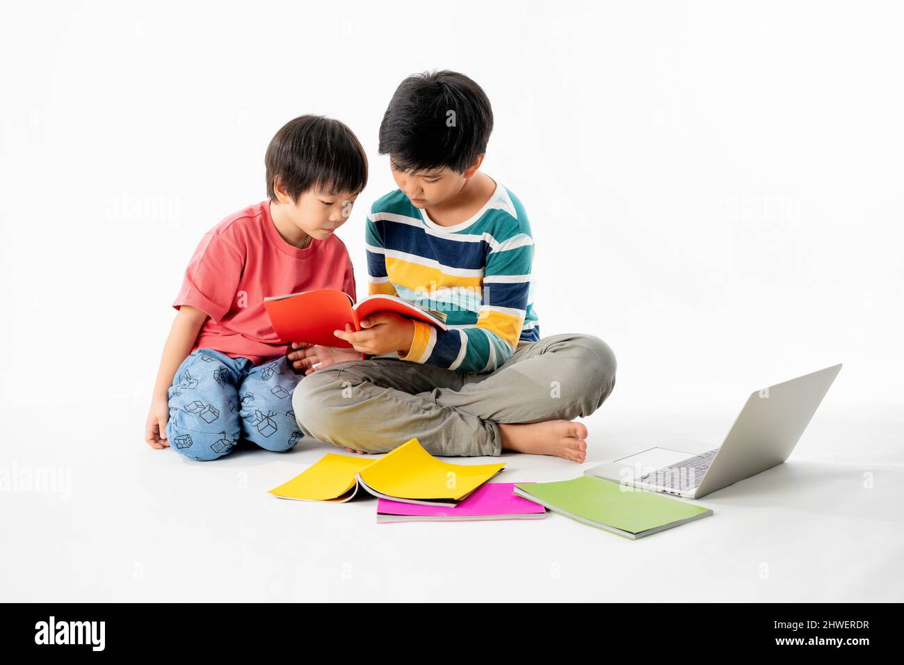 Portrait of Happy asian boys, Brother on floor with laptop and books ...