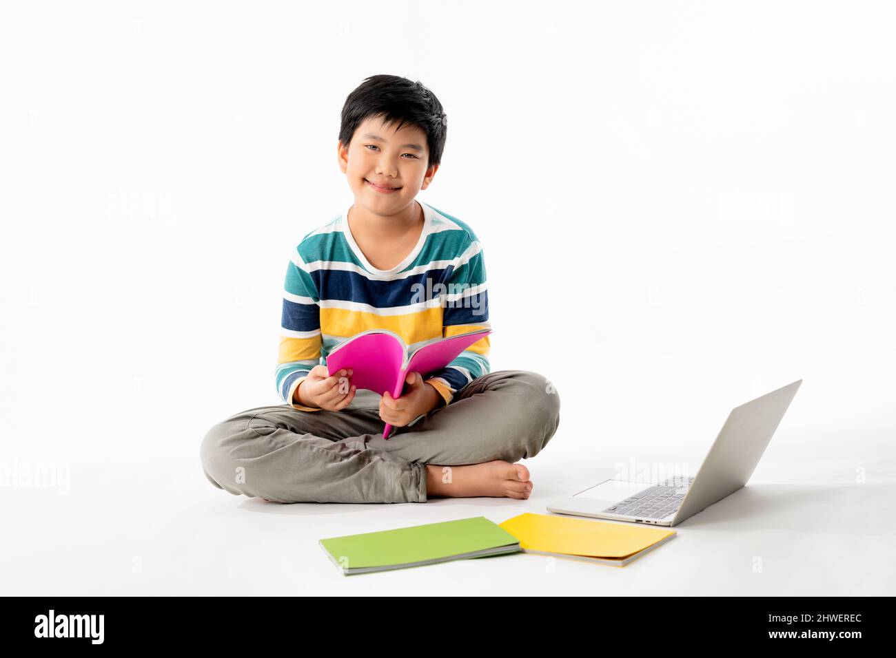 Portrait of Happy asian boy on floor with laptop and books isolated on ...