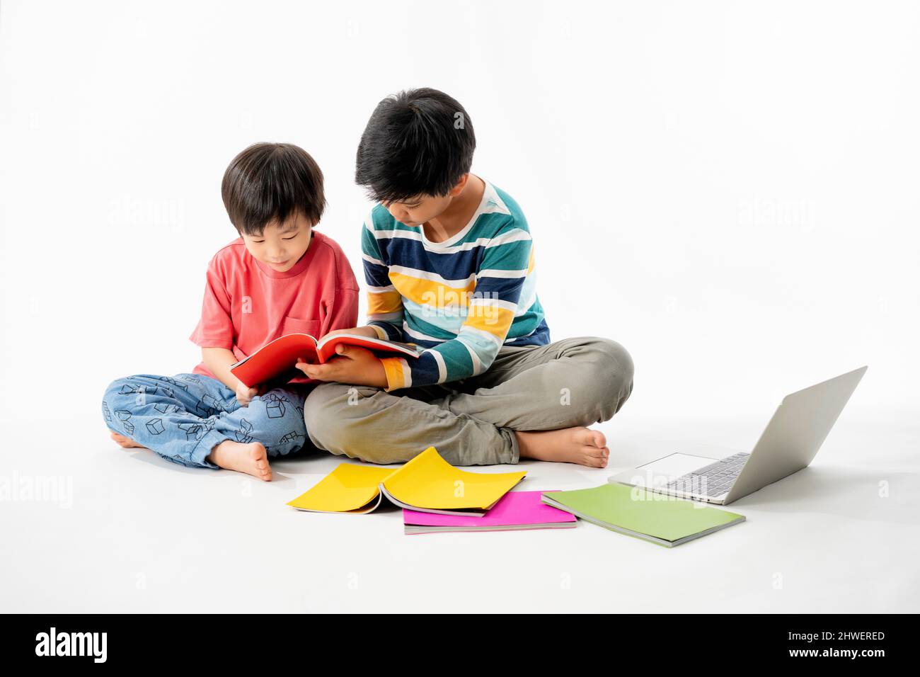 Portrait of Happy asian boys, Brother on floor with laptop and books ...