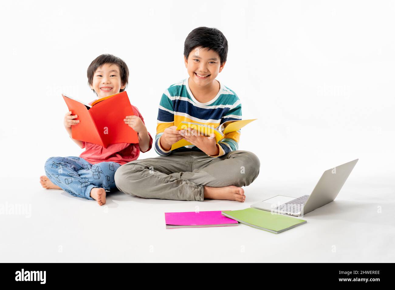 Portrait of Happy asian boys, Brother on floor with laptop and books ...