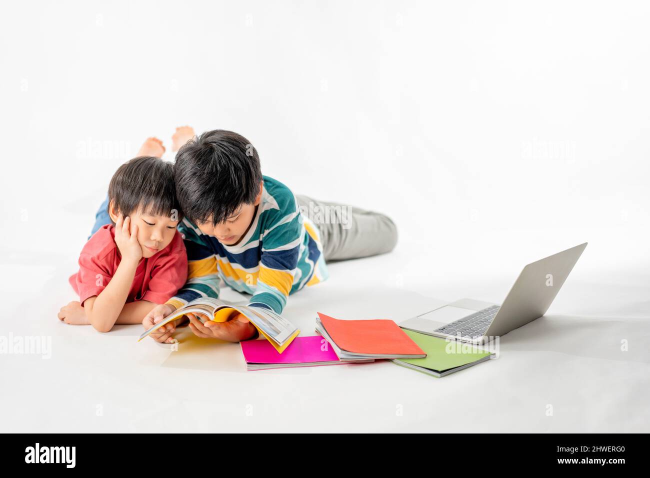 Portrait of Happy asian boys, Brother on floor with laptop and books ...