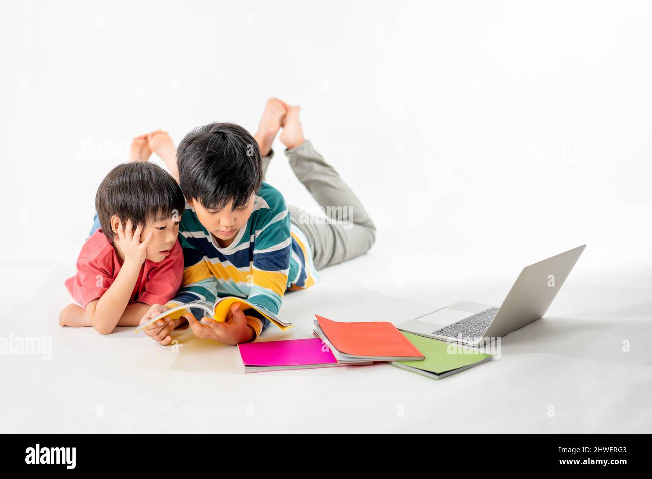 Portrait of Happy asian boys, Brother on floor with laptop and books ...