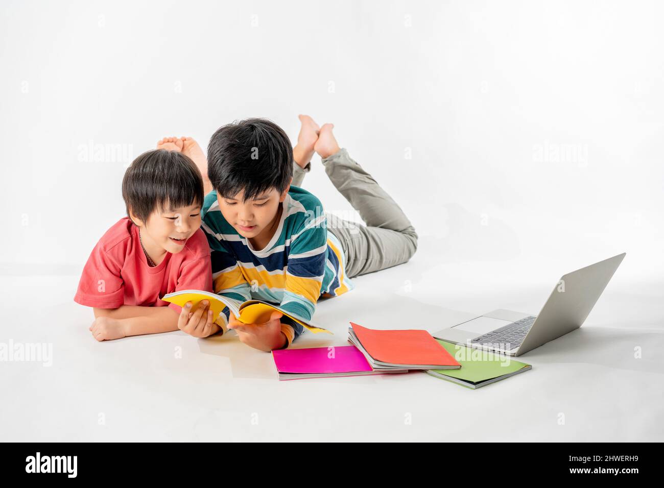 Portrait of Happy asian boys, Brother on floor with laptop and books ...