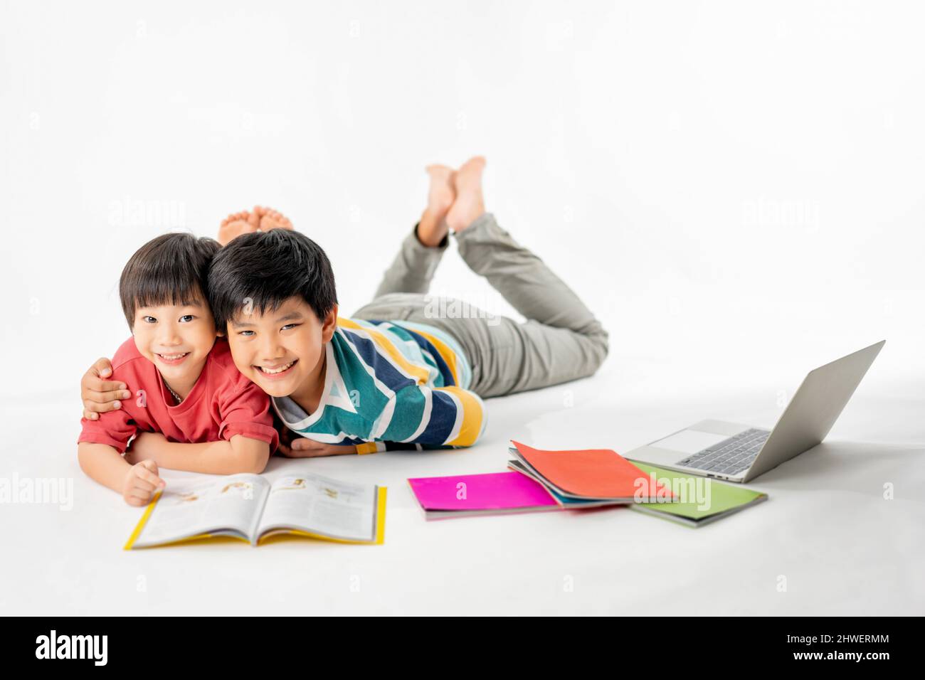 Portrait of Happy asian boys, Brother on floor with laptop and books ...