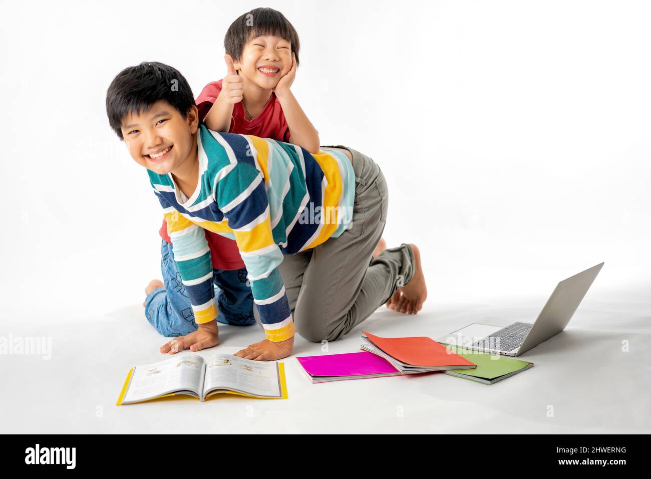 Portrait of Happy asian boys, Brother on floor with laptop and books ...