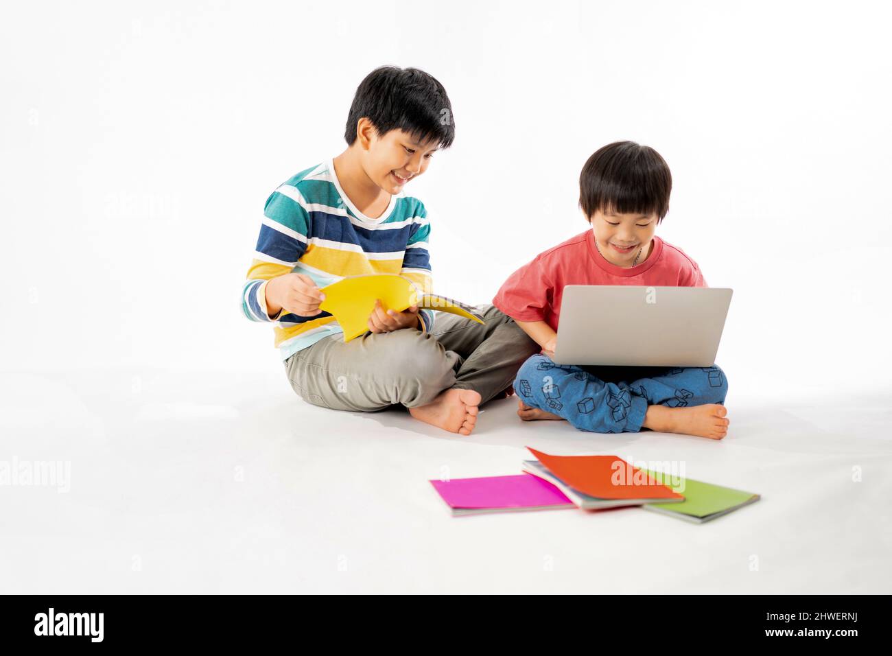 Portrait of Happy asian boys, Brother on floor with laptop and books ...