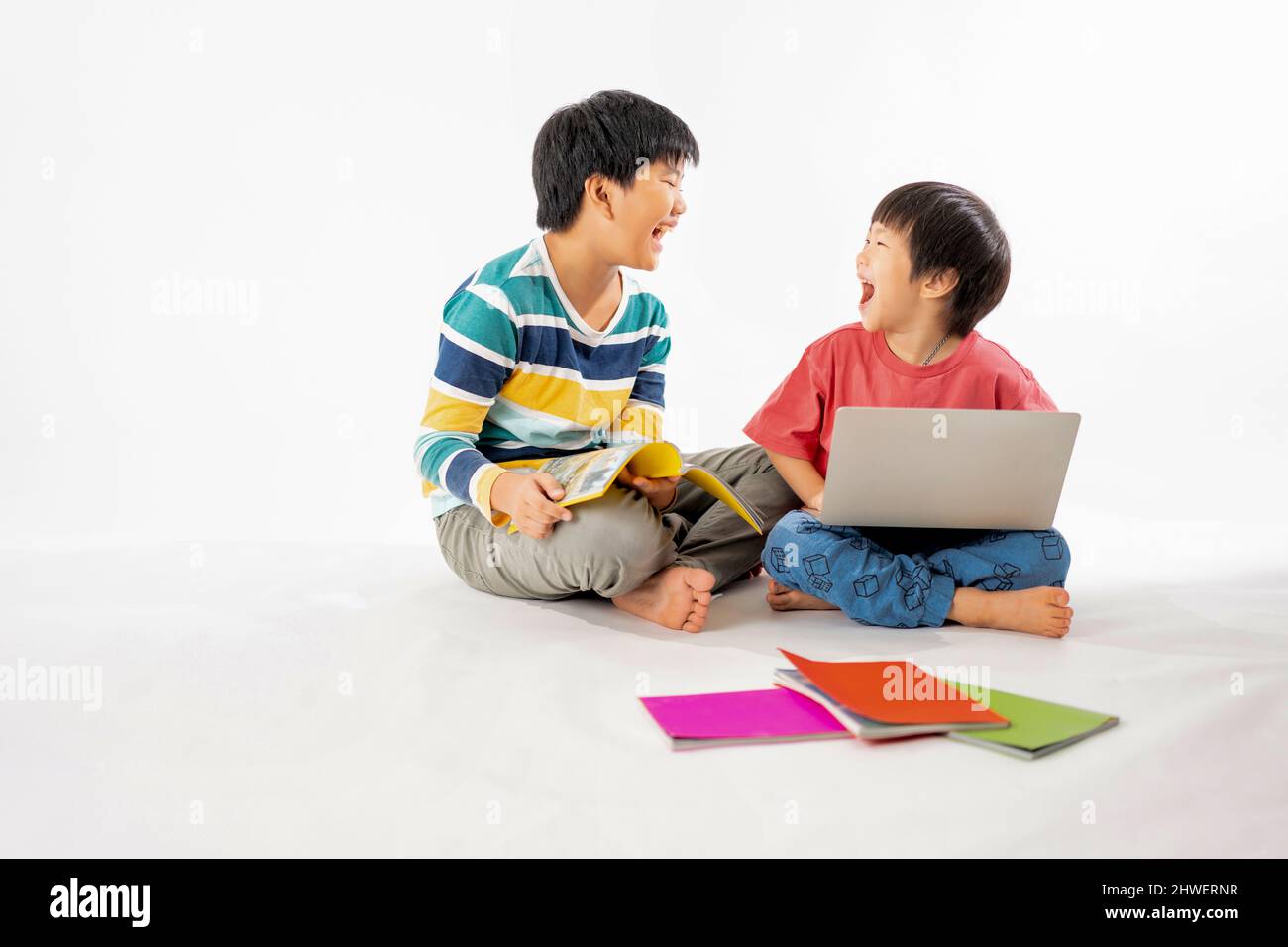 Portrait of Happy asian boys, Brother on floor with laptop and books ...