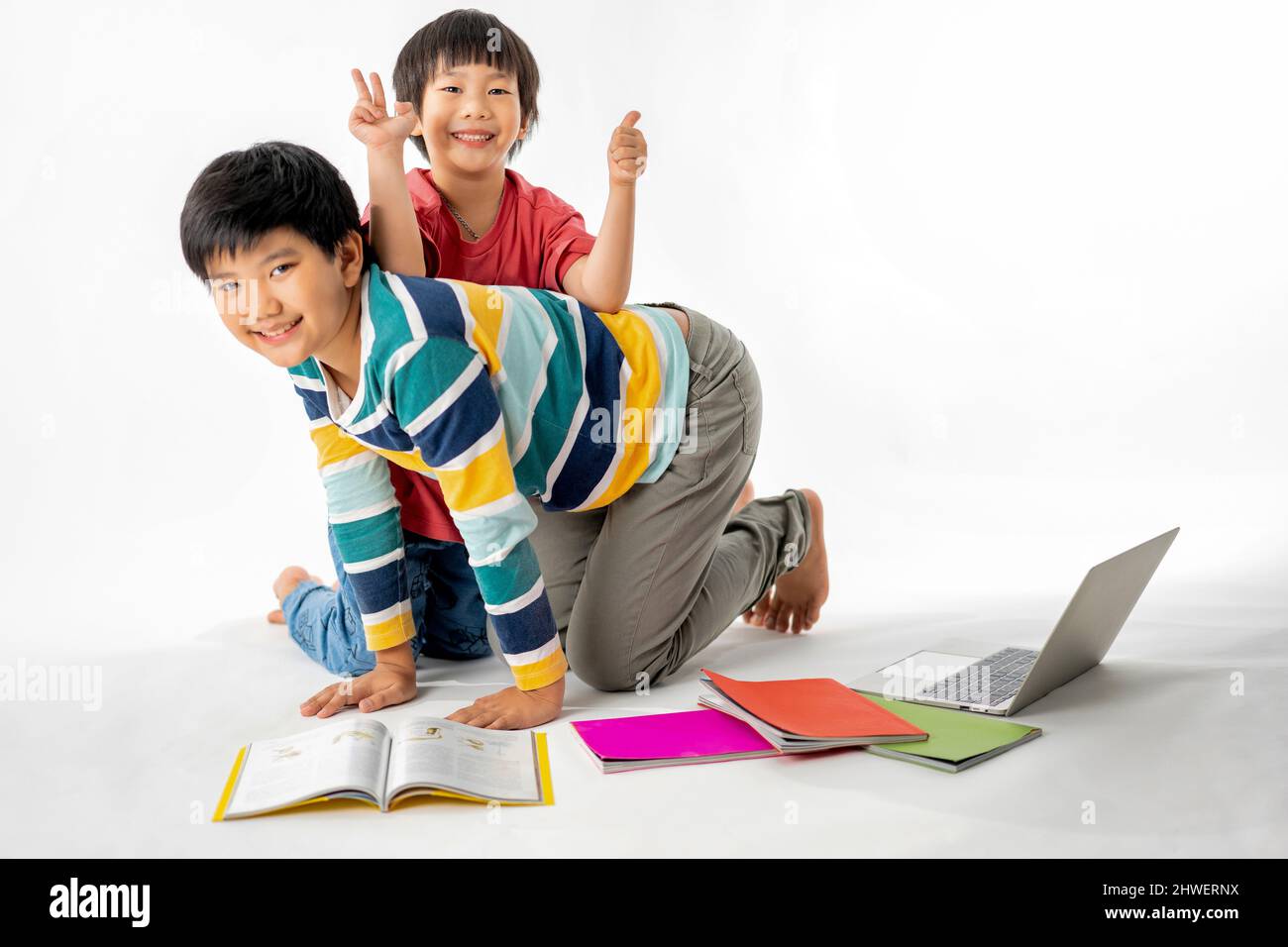 Portrait of Happy asian boys, Brother on floor with laptop and books ...