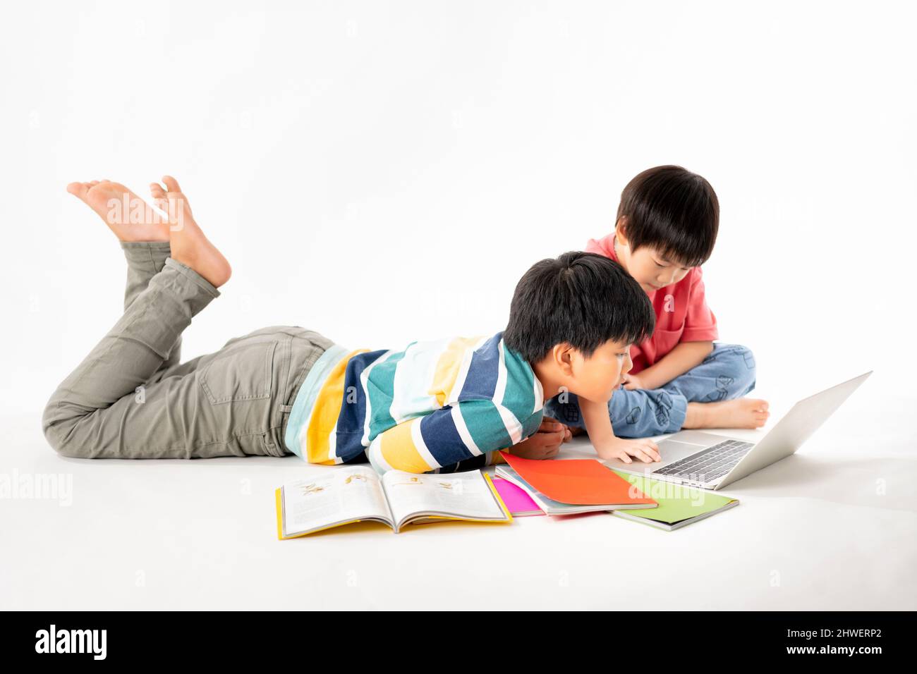 Portrait of Happy asian boys, Brother on floor with laptop and books ...