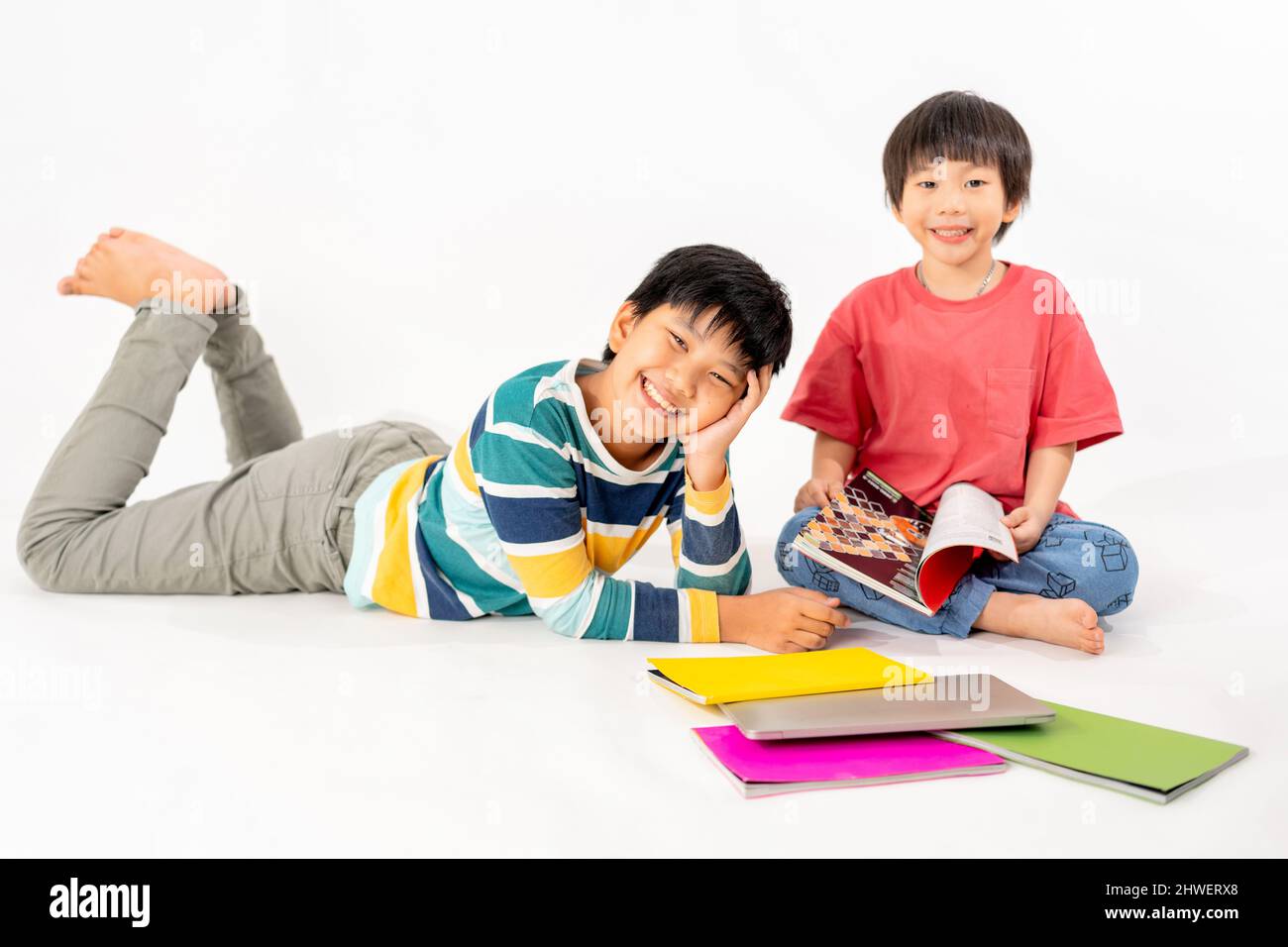 Portrait of Happy asian boys, Brother on floor with laptop and books ...