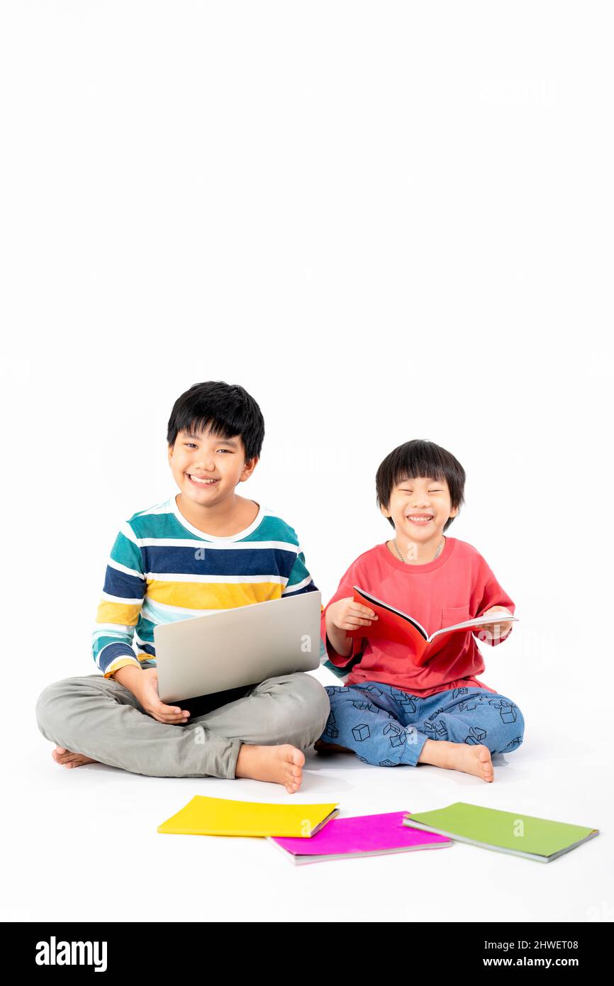 Portrait of Happy asian boys, Brother on floor with laptop and books ...