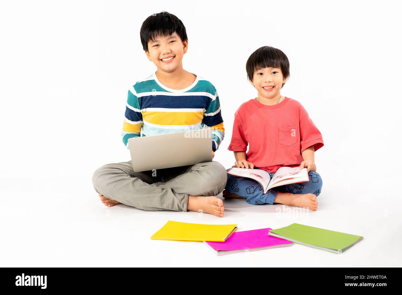 Portrait of Happy asian boys, Brother on floor with laptop and books ...